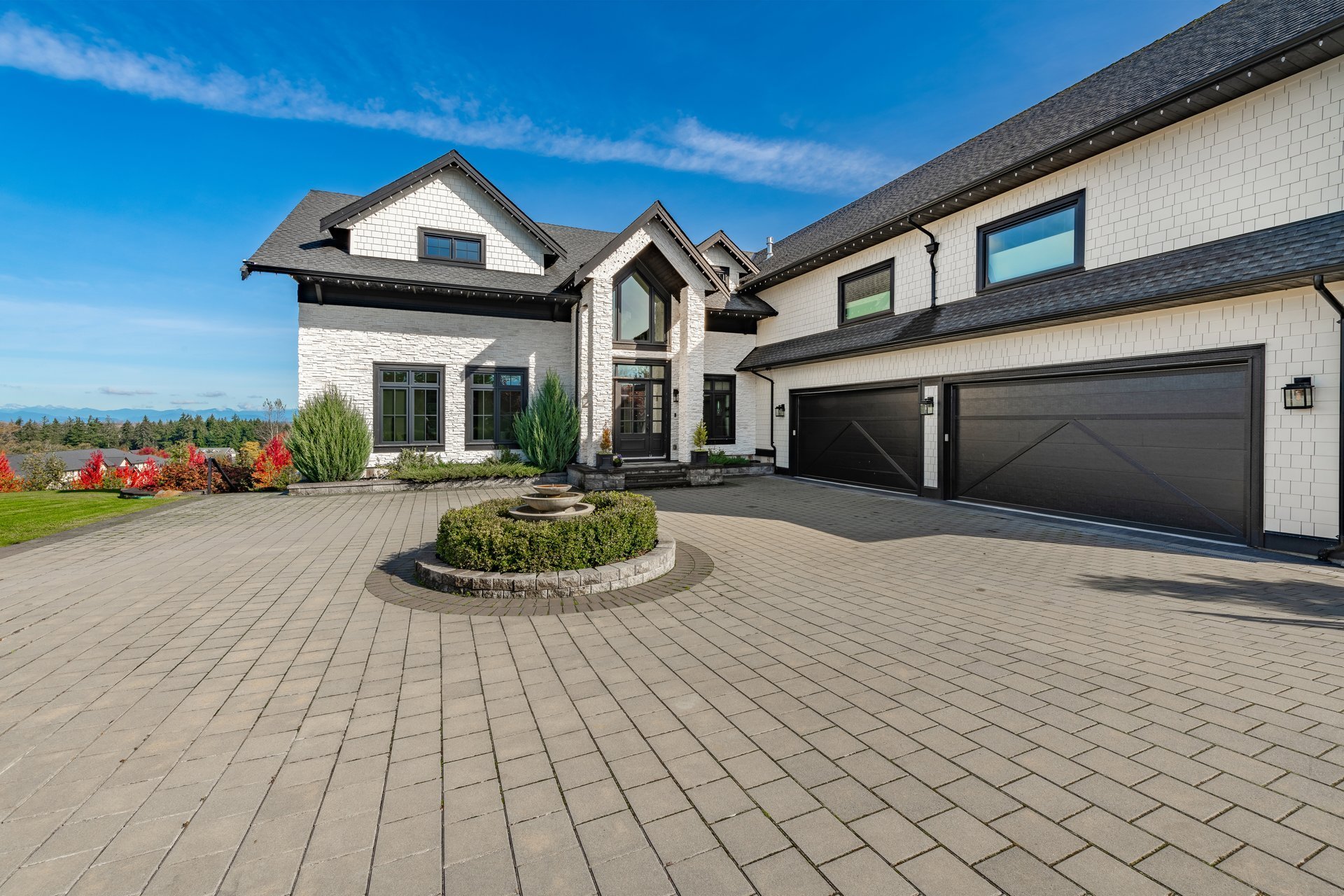 Elegant Florida home with pristine sealed paver driveway on a sunny day with lush landscaping