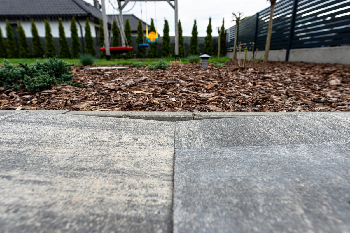 Paver pool deck with sand washout from splash-out showing why re-sanding is needed in Marion County FL